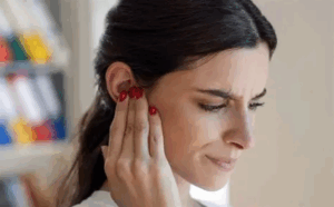 Women touching her ear.