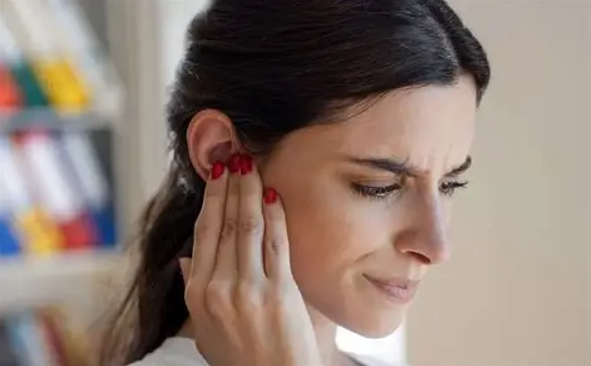 Women touching her ear.
